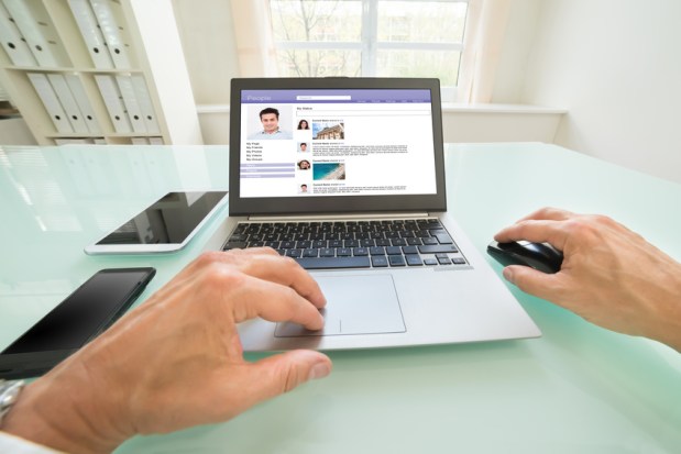 Close-up Of A Person Chatting On Social Website In Office. Photographer owns copyright for images on screen